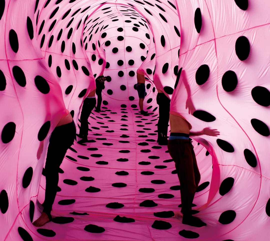 Pink Flashbacks No.1 -THE TRANSPARENT TONGUE 2012 - for SS13 Collection, Lycée Turgot, Paris, France and Kunsthal Charlottenborg; Copenhagen, Denmark. Inspired by the fleshy muscular organ of the mouth, the SS13 collection featured a 20-meter length of fabric tongue covered in black taste buds, ready to lick what lay ahead. Activated by dancers emerging from various spots of the surface, a slow motion cleaning performance began, adding the last functional layer to this sensitive implement. Photo @TueJuelsbo