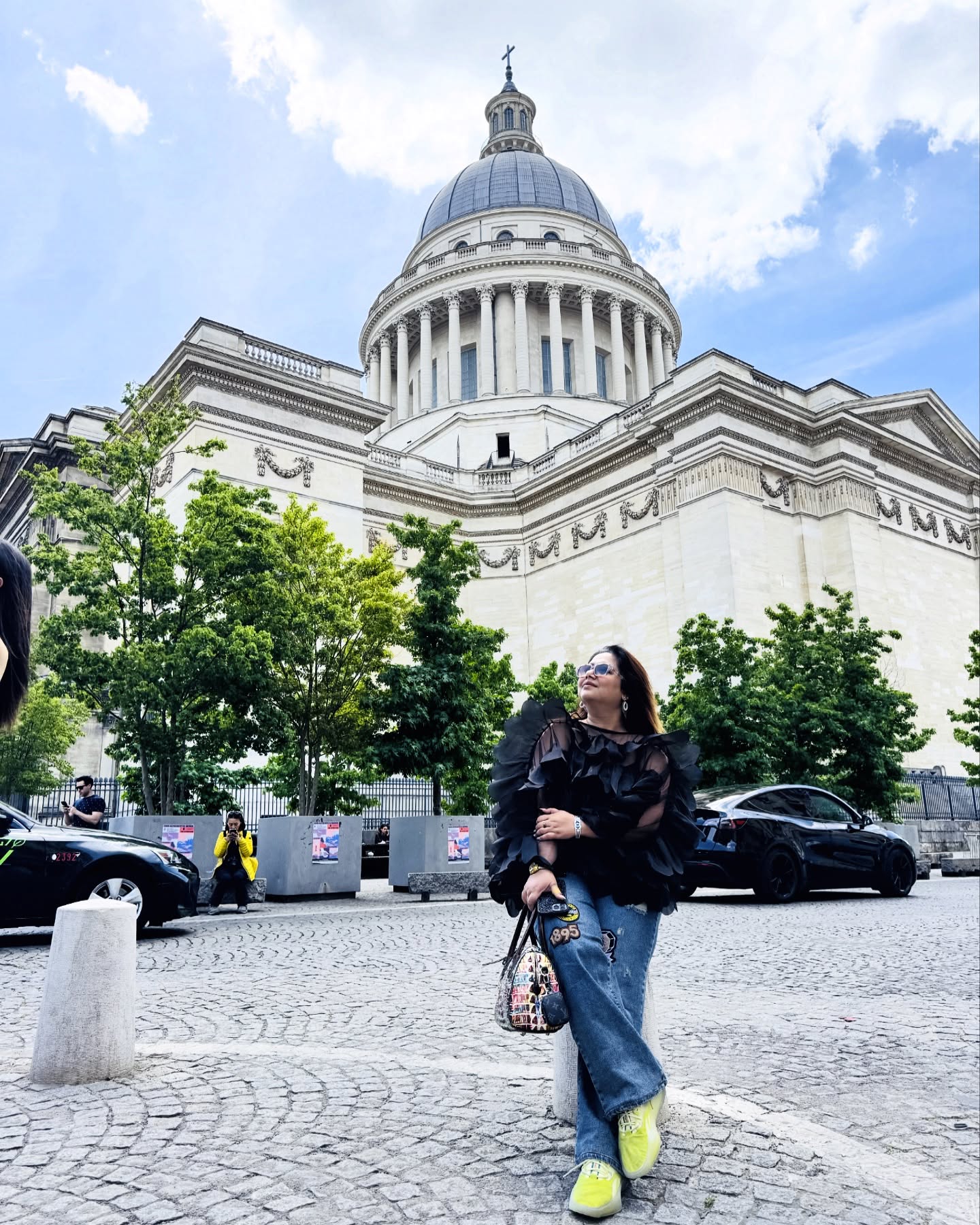 An independent girl sits calmly on the stone steps beside the Pantheon in Paris. The grandeur of the neoclassical columns rises behind her, but she is undistracted—lost in her own world. A leather journal rests open on her lap, its pages filled with scribbles of thoughts, dreams, and plans. She’s dressed simply but stylishly—jeans, a black swan top, and sunglasses pushed back into her hair. The hum of Parisian life surrounds her, but she radiates a quiet strength, as if the city is merely a backdrop to her own unfolding story. @pantheon_paris #eramsentertainment #eramfaridiproducer #producerslife #paris #eramfaridi