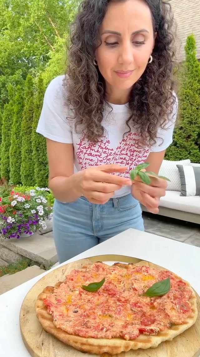 For all my baked feta pasta fans, you need to try this grilled feta pizza! 🍕 #AthenosPartner Use a foil packet to grill the tomatoes with a block of @AthenosFeta. It creates a tangy and cheesy sauce that’s really unexpected and so delicious, especially if you’re looking for something new to throw on your pizza! #AthenosFeta #FoodNeedsfeta
INGREDIENTS
1 cup grape tomatoes, halved
1 (8-ounce) Athenos Feta block (drained)
3 garlic cloves
2 tablespoons olive oil, plus more for brushing
1 tablespoon chopped basil
¼ teaspoon freshly ground black pepper
1 pound pizza dough, room temperature
Handful fresh basil leaves
INSTRUCTIONS
1. Preheat the grill to high (500°F).
2. On a large piece of foil, place the tomatoes, feta, garlic, olive oil, basil and black pepper in a small pile. Wrap the foil edges to close into a pocket and place on the preheated grill for 15 minutes or until the tomatoes burst and the feta cheese melts.
3. Meanwhile, place a large piece of parchment paper on a flat surface and lightly flour the surface. Stretch 1 pound pizza dough into a 12–14 inch round on top of the parchment paper. Brush the top with a drizzle of olive oil.
4. Place the dough, oiled side down, onto the hot grates. Close the lid and cook 2–3 min until the bottom is firm with light char. Brush the exposed side with more olive oil, flip, and grill 2 more minutes.
4. Remove the crust and set aside on a platter.
5. When the feta and tomatoes are done cooking, carefully open the foil packet and use a fork to mash the tomatoes and feta together to create a thick sauce. 6. Transfer the sauce on top of the grilled pizza dough. Top it with fresh basil leaves. Slice and enjoy immediately.