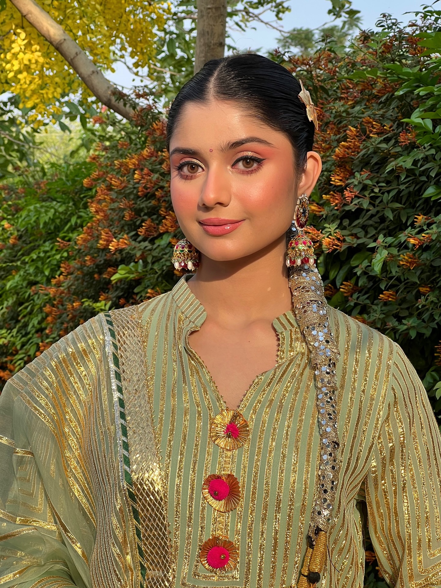 A radiant, glowy makeup look featuring coral-peach pink cheeks that give a natural, sun-kissed flush. The skin beams with dewy luminosity, while the lips are soft, juicy, and glossy in a fresh flushy pink. A heightened winged liner lifts and defines the eyes, adding a playful edge. The overall vibe is ultra-fresh, youthful, and glowing from within.
..
Makeup : @satpreetkaurmakeovers
Hair : @hairstylistsapna
Wearing : @turquoisestudiobysimran
Jewellery : @vbhushan.adornments